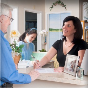 Receptionist welcoming a patient at the front desk